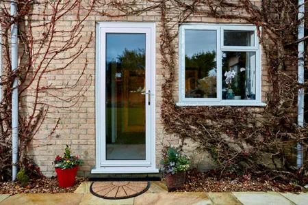 White UPVC double glazed back door with clear glass and matching casement window from Anglian Home Improvements