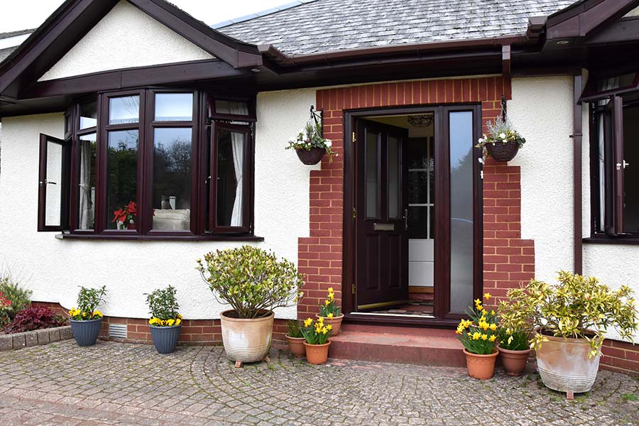 Dark woodgrain composite classic door with silver mist and bay windows