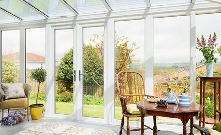 White PVCU Garden Room with French doors and garden view