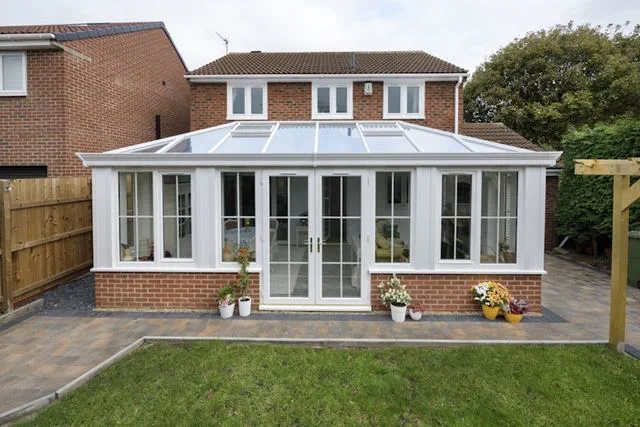 Classic white Orangery with white uPVC French doors and windows with Georgian bars